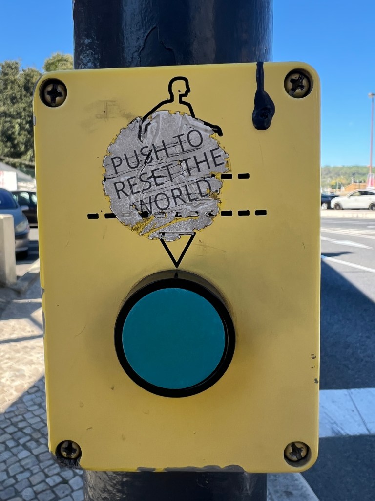 Sticker image "push to reset the world" stuck on the crosswalk button
